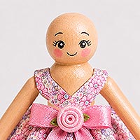Instructional image showing the placement of the doll's facial features, including open eyes with eyelashes and eyebrows, a smiling mouth, and soft pink painted cheeks, for creating a cheerful expression on a handmade doll pin doll.