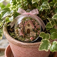 Miniature fairy garden fillable ornament craft idea featuring a whimsical fairy cottage for home d�cor, flower pots, and magical garden displays.
